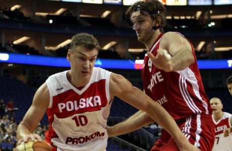Poland's Adam Wojcik, left, goes past Turkey's Semih Erden, during the Game  on at the O2 basketball event at the O2 Arena, London, Sunday Aug. 16, 2009. (AP Photo/Tom Hevezi)