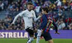 Valencia's Samu Castillejo, left, and Barcelona's Marcos Alonso vie for the ball during Spanish La Liga soccer match between Barcelona and Valencia at the Camp Nou stadium in Barcelona, Spain, Sunday, March 5, 2023. (AP Photo/Joan Monfort)
