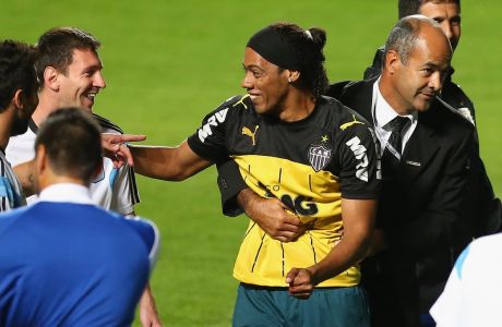 BELO HORIZONTE, BRAZIL - JUNE 11:  A fan bearing the resemblance of Ronaldinho is escorted off the field while talking to Lionel Messi of Argentina after an open trainging session ahead of the 2014 FIFA World Cup on June 11, 2014 in Belo Horizonte, Brazil.  (Photo by Ronald Martinez/Getty Images)