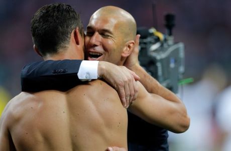 Real Madrid's Cristiano Ronaldo is embraced by Real Madrid's headcoach Zinedine Zidane after scoring the winning penalty shot during the Champions League final soccer match between Real Madrid and Atletico Madrid at the San Siro stadium in Milan, Italy, Saturday, May 28, 2016. Real Madrid won 5-4 on penalties after the match ended 1-1 after extra time.   (AP Photo/Manu Fernandez)