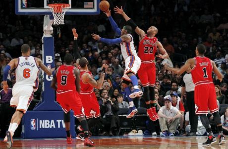 New York Knicks forward Carmelo Anthony (C) drives to the hoop defended by Chicago Bulls forward Taj Gibson (22) in the second quarter of their NBA basketball game at Madison Square Garden in New York, April 8, 2012.  REUTERS/Adam Hunger (UNITED STATES - Tags: SPORT BASKETBALL)