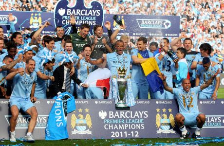 MANCHESTER, ENGLAND - MAY 13:  The Manchester City players celebrate with the trophy following the Barclays Premier League match between Manchester City and Queens Park Rangers at the Etihad Stadium on May 13, 2012 in Manchester, England.  (Photo by Alex Livesey/Getty Images)