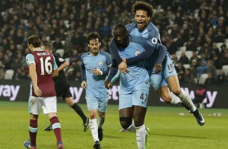 Manchester City's Leroy Sane jumps onto Manchester City's Yaya Toure after he scores a goal during the English Premier League soccer match between West Ham and Manchester City at the London stadium, Wednesday, Feb. 1, 2017. (AP Photo/Frank Augstein)