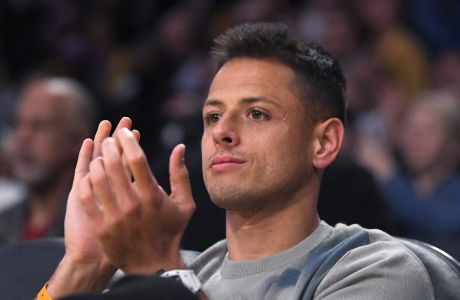 Los Angeles Galaxy striker Chicharito claps as he watches during the first half of an NBA basketball game between the Los Angeles Lakers and the Philadelphia 76ers Tuesday, March 3, 2020, in Los Angeles. (AP Photo/Mark J. Terrill)
