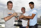 Serbia's Novak Djokovic, right,  passes his Australian Open trophy to his uncle Goran, left, as friend Igor Cetojevic, centre, looks on at a photo shoot  in Melbourne, Australia, Monday, Jan. 31, 2011. Djokovic defeated Britain's Andy Murray in the final on Sunday Jan 30.  (AP Photo/Vincent Thian)