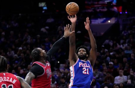 Philadelphia 76ers' Joel Embiid, right, goes up for a shot against Chicago Bulls' Andre Drummond, center, during the first half of an NBA basketball game, Tuesday, Jan. 2, 2024, in Philadelphia. (AP Photo/Matt Slocum)