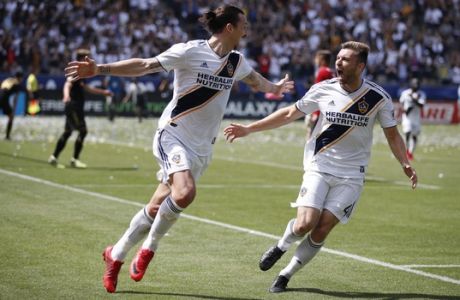 Los Angeles Galaxy's Zlatan Ibrahimovic, left, of Sweden, celebrates his second goal of the game with Dave Romney during the second half of an MLS soccer match against the Los Angeles FC Saturday, March 31, 2018, in Carson, Calif. The Galaxy won 4-3. (AP Photo/Jae C. Hong)