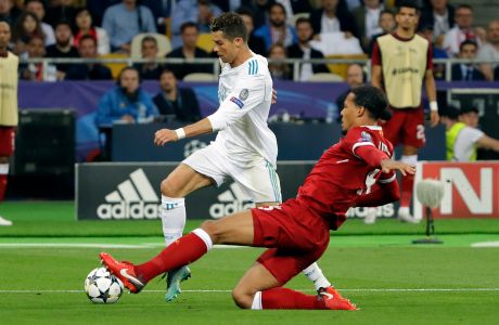Real Madrid's Cristiano Ronaldo, left, and Liverpool's Virgil Van Dijk challenge for the ball during the Champions League Final soccer match between Real Madrid and Liverpool at the Olimpiyskiy Stadium in Kiev, Ukraine, Saturday, May 26, 2018. (AP Photo/Sergei Grits)