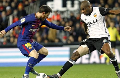 FC Barcelona's Lionel Messi, left, duels for the ball with Valencia's Geoffrey Kondogbia, right, during the Spanish Copa del Rey, semifinal, second leg, soccer match between FC Barcelona and Valencia at the Mestalla stadium in Valencia, Spain, Thursday Feb. 8, 2018. (AP Photo/Alberto Saiz)