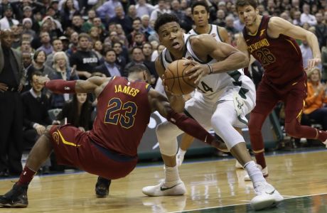 Milwaukee Bucks' Giannis Antetokounmpo gabs a loose ball in front of Cleveland Cavaliers' LeBron James during the second half of an NBA basketball game Tuesday, Dec. 19, 2017, in Milwaukee. The Bucks won 119-116. (AP Photo/Morry Gash)