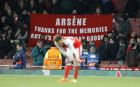 Arsenal's Alex Oxlade-Chamberlain reacts as Arsenal fans hold up a banner after the Champions League round of 16 second leg soccer match between Arsenal and Bayern Munich at the Emirates Stadium in London, Tuesday, March 7, 2017. Arsenal lost the match 5-1 and 10-2 on aggregate. (AP Photo/Frank Augstein)