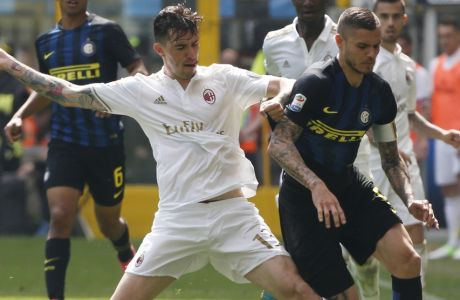 AC Milan's Alessio Romagnoli, left, and Inter Milan's Mauro Icardi vie for the ball during an Italian Serie A soccer match between Inter Milan and AC Milan, at the San Siro stadium in Milan, Italy, Saturday, April15, 2017. (AP Photo/Antonio Calanni)
