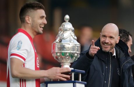 FILE- Ajax's head coach Erik ten Hag, right, gestures as captain Dusan Tadic is about to lift the trophy after winning the TOTO KNVB Cup final soccer match between Ajax and Vitesse at De Kuip stadium in Rotterdam, Netherlands, Sunday April 18, 2021. Dutch media are reporting that Ten Hag has reached a verbal agreement to coach Manchester United. (AP Photo/Peter Dejong, Pool, File)